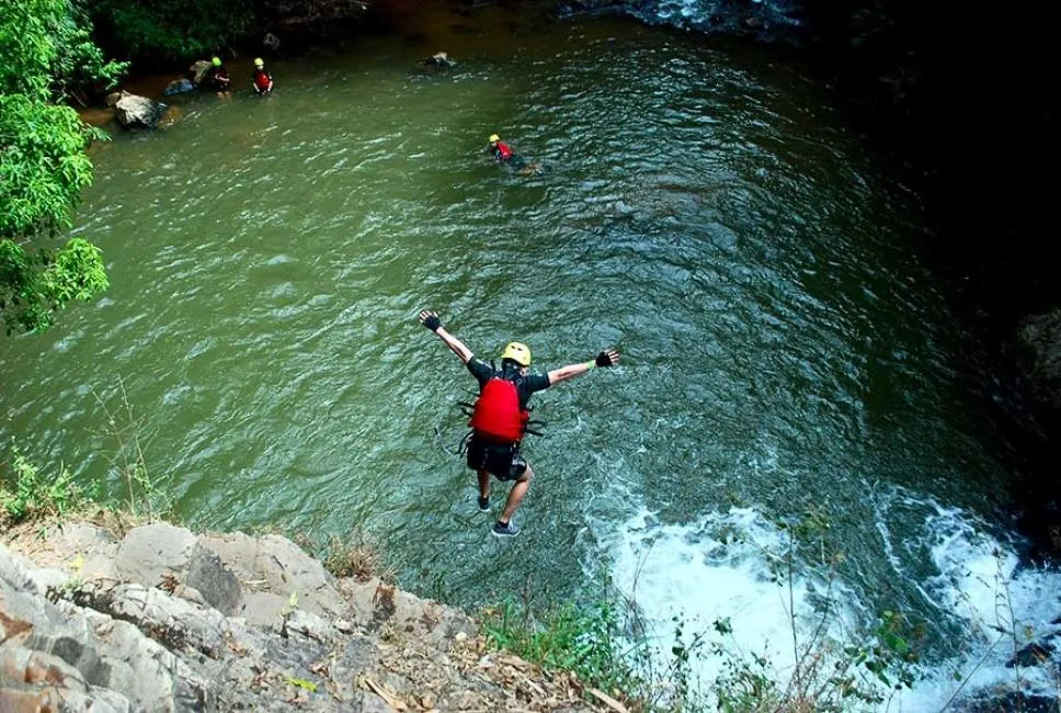 Waterfall Jumping Experience in Da Lat Canyoning A traveler jumping into a natural pool during the Da Lat Canyoning Adventure tour