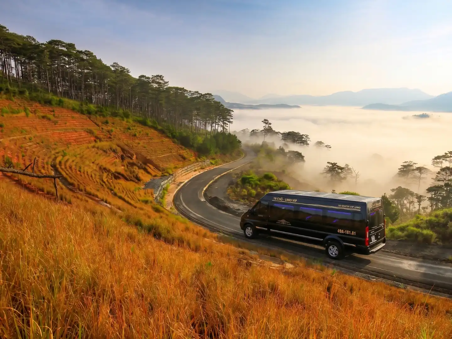Comfortable tour transit through scenic mountain roads enveloped in morning mist heading toward Dalat highlands